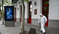 A worker disinfects a bench in Madrid on April 28, 2020 during a national lockdown to prevent the spread of the COVID-19 disease. Spain recorded a slight decrease in the number of daily coronavirus deaths with the government set to unveil plans to relax s