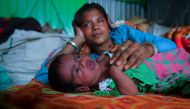 This picture taken on April 28, 2020, shows 23-year-old Manju Bauri resting next to her newborn baby boy named 'Lockdown' in their temporary rented quarter in Agartala. AFP / Abhisek Saha 