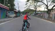 A boy rides a bicycle along a deserted National Highway 55 during a government-imposed nationwide lockdown as a preventive measure against the COVID-19 coronavirus, at Sukna on the outskirts of Siliguri on April 29, 2020. / AFP / DIPTENDU DUTTA
