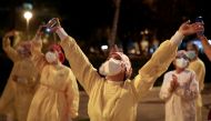 FILE PHOTO: Health workers gesture as citizens show their support from their balconies and windows, amid the spread of the coronavirus disease (COVID-19), in Barcelona, Spain April 15, 2020. REUTERS/Nacho Doce/File Photo