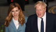 (FILES) In this file photo taken on September 28, 2019 Britain's Prime Minister Boris Johnson (R) walks with his partner Carrie Symonds as they arrive at The Midland, near the Manchester Central convention complex in Manchester, northwest England . AFP / 