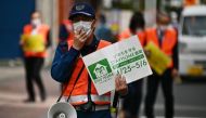 Municipal employees patrol a street asking people to stay home amid the COVID-19 coronavirus outbreak in Tokyo on May 4, 2020. AFP / CHARLY TRIBALLEAU
