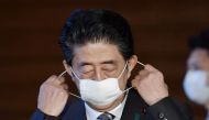 Japan's Prime Minister Shinzo Abe puts off his protective face mask as he speaks to media on Japan's response to the coronavirus disease (COVID-19) outbreak at his official residence in Tokyo, Japan, May 1, 2020, in this photo taken by Kyodo. 