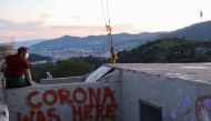 A man wears a protective face mask at a lookout point as a general view of the city of Barcelona is seen in the background, as the spread of the coronavirus disease (COVID-19) continues, in Barcelona, Spain May 6, 2020. REUTERS/Nacho Doce
