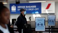 Passengers wearing protective face masks maintain social distance as they queue in Terminal 2E at Paris Charles de Gaulle airport in Roissy-en-France during the outbreak of the coronavirus disease (COVID-19) in France, May 6, 2020. REUTERS/Benoit Tessier