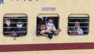 Migrant workers and families wave from the windows of a special train from Amritsar to Barauni of Bihar state as they go back to their hometowns after the government eased a nationwide lockdown imposed as a preventive measure against the COVID-19 coronavi