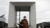 People wearing protective face masks walk at the financial and business district of La Defense near Paris as France begun a gradual end to a nationwide lockdown due to the coronavirus disease (COVID-19), May 11, 2020. REUTERS/Gonzalo Fuentes