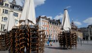 Stacked chairs are seen on the terrace of a closed restaurant at the Grand Place in Lille, after France begun a gradual end to a nationwide lockdown due to the coronavirus disease (COVID-19) in France, May 11, 2020. REUTERS/Pascal Rossignol