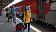 People with their luggage walk to board a train that will take them to New Delhi after India announced a limited reopening of its giant rail network following a nearly seven-week lockdown to slow the spreading of the coronavirus disease (COVID-19), at the