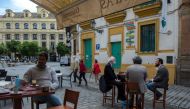 People have breakfast at a cafe in Sevilla on May 11, 2020 as Spain moved towards easing its strict lockdown in certain regions.  / AFP / CRISTINA QUICLER