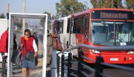 A commuter reacts as she is sprayed with sanitiser via walk-through 'tunnels' before boarding public transport, as South African President Cyril Ramaphosa said on Wednesday he aims to further ease restrictions imposed to curb the coronavirus disease (COVI