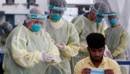 :Medical workers prepare to perform a nose swab on a migrant worker at a dormitory, amid the coronavirus disease (COVID-19) outbreak in Singapore May 15, 2020. REUTERS/Edgar Su
