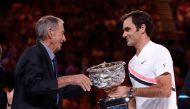 FILE PHOTO: Tennis - Australian Open - Men's singles final - Rod Laver Arena, Melbourne, Australia, January 28, 2018. Switzerland's Roger Federer is presented with the trophy by former player Ashley Cooper after winning the final against Croatia's Marin C