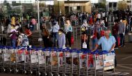 An airport staff member pushes trollies at the entrance of Chhatrapati Shivaji International Airport, after the government allowed domestic flight services to resume, during an extended nationwide lockdown to slow the spread of the coronavirus disease (CO