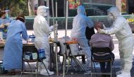Health workers wearing protective gear take samples from a visitor for the COVID-19 coronavirus test at a temporary virus testing centre in Seoul on May 29, 2020. / AFP / YONHAP /
