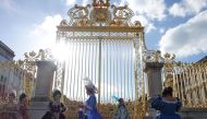 (FILES) In this file photograph taken on June 1, 2015, women dressed in period costume wait for the gates of the 