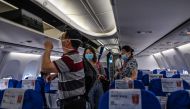 Passengers wearing facemasks board a flight to Shanghai at Tianhe Airport in Wuhan, in China’s central Hubei province on May 29, 2020. / AFP / Hector RETAMAL
