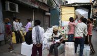 Workers gather outside a shop while others load a vehicle after the government eased a nationwide lockdown imposed as a preventive measure against the COVID-19 coronavirus, in the old quarters of New Delhi on June 5, 2020. / AFP / XAVIER GALIANA