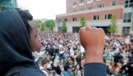 FILE PHOTO: Demonstrators raise their fists as they take a knee for 8 minutes 46 seconds, the length of time George Floyd was held down with a knee on his neck by a Minneapolis Police officer, during a protest against racial inequality in the aftermath of