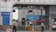 Chinese paramilitary police officers guard an entrance to the closed Xinfadi market in Beijing on June 13, 2020. AFP / GREG BAKER