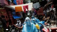Healthcare workers wearing personal protective equipment (PPE) and volunteers walk through a slum in Dharavi, one of Asia's largest slums, to check residents during a lockdown to slow the spread of the coronavirus disease (COVID-19), in Mumbai, India, Jun