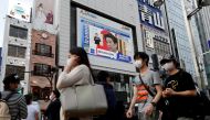 FILE PHOTO: A large screen on a building shows live broadcast of Japan's Prime Minister Shinzo Abe's news conference on the lifting of the state of emergency in Tokyo and the remaining 5 areas still under alert for the coronavirus disease (COVID-19) at Sh