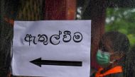 An election official stands to enter a polling station ahead of a mock election to test the guidelines implemented against the COVID-19 coronavirus in Ingiriya of Kalutara District in Western Province on June 14, 2020. AFP / LAKRUWAN WANNIARACHCHI
