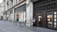 An employee finishes setting out the barriers to aid queuing at Nike Town sports retail store an hour before opening time on Oxford Street in London on June 16, 2020. AFP / JUSTIN TALLIS