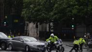 A protester from a pro-Kurdish demonstration is stopped and detained by police officers as he ran towards the car of Britain's Prime Minister Boris Johnson (C) as it was leaving with a police escort from the Houses of Parliament in London on June 17, 2020