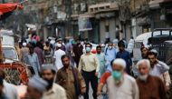 A man wears a protective face mask as he walks among other people along a street, as the outbreak of the coronavirus disease (COVID-19) continues, in Karachi, Pakistan June 16, 2020. REUTERS/Akhtar Soomro
