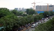 People line up to go into a makeshift testing center to receive nucleic acid tests after a new outbreak of the coronavirus disease (COVID-19) in Beijing, China, June 18, 2020. REUTERS/Thomas Peter