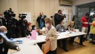 A voter wearing a face mask collects ballot papers during national election, the first in Europe since coronavirus lockdown, at a polling station in Belgrade, Serbia, June 21, 2020. REUTERS/Marko Djurica