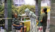 A man receives a nucleic acid test at a makeshift testing site in a residential compound after a new outbreak of the coronavirus disease (COVID-19) in Beijing, China June 21, 2020. REUTERS/Thomas Peter
