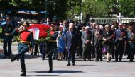 Russian President Vladimir Putin (C) takes part in a wreath-laying ceremony at the Tomb of the Unknown Soldier by the Kremlin wall on the Day of Remembrance and Sorrow on the 79th anniversary of the Nazi invasion of the Soviet Union, in downtown Moscow on
