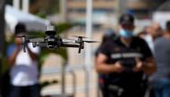 A local police officer flies a drone warning people to respect safety rules on a beach in Lloret de Mar on June 22, 2020. AFP / Josep LAGO