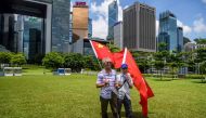 Pro-China supporters display Chinese and Hong Kong flags as they raise a toast with champagne during a rally near the government headquarters in Hong Kong on June 30, 2020, as China passed a sweeping national security law for the city.   AFP / Anthony WAL