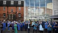 Members of the emergency services and staff of the Leeds General Infirmary participate in a national NHS (National Health Service) celebration clap outside the hospital in Leeds on July 5, 2020, to mark its 72nd anniversary. / AFP / Oli SCARFF
