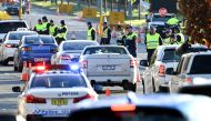 Police in the southern New South Wales (NSW) border city of Albury check cars crossing the state border from Victoria on July 8, 2020 after authorities closed the border due to an outbreak of COVID-19 coronavirus in Victoria. With the city of Melbourne go