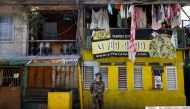 A soldier wearing a protective mask guards a street while children look out from a balcony, as the city undergoes a stricter lockdown to contain the coronavirus disease (COVID-19) spread, in Pasay City, Philippines, April 22, 2020. REUTERS/Eloisa Lopez/Fi