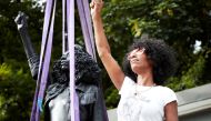 Jen Reid poses next to a sculpture by Marc Quinn portraying her, titled 'A Surge of Power (Jen Reid) 2020', in London, Britain July 14, 2020, in this image obtained from social media. Picture taken July 14, 2020. Courtesy of Marc Quinn Studio/via REUTERS