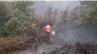 A volunteer firefighter walks to throw water to control a wildfire at Monte Fundeiro, Oleiros, portugal July 26, 2020 in this still image taken from social media video. APROSOC via REUTERS 