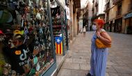 FILE PHOTO: A woman looks at masks displayed at a souvenir shop, amid the coronavirus disease (COVID-19) outbreak, in Barcelona, Spain July 27, 2020. REUTERS/Albert Gea/File Photo
 
