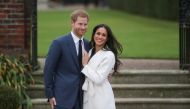 In this file photo taken on November 27, 2017 Britain's Prince Harry and his fiancée US actress Meghan Markle pose for a photograph in the Sunken Garden at Kensington Palace in west London on November 27, 2017, following the announcement of their engageme