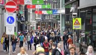 Tourists walk at Kalverstraat, a shopping street in AMSTERDAM on July 25, 2020 as the municipality has stricter supervision over the weekend and one-way traffic was set up for pedestrians on a certain section of the street due to the increasing number of 