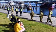 A group of police and soldiers patrol the Docklands area of Melbourne on August 2, 2020. AFP / William WEST
