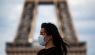 A woman wearing a protective face mask walks at the Trocadero square near the Eiffel Tower in Paris as France reinforces mask-wearing as part of efforts to curb a resurgence of the coronavirus disease (COVID-19) across the country, August 3, 2020. REUTERS