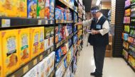 A worker with a face shield checks products on the shelf of a grocery store in the Manhattan borough of New York City, New York, U.S., August 7, 2020. REUTERS/Carlo Allegri