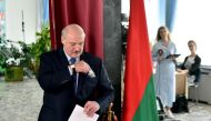 Belarusian President Alexander Lukashenko holds a ballot and a passport before casting his vote at a polling station during the presidential election in Minsk, Belarus August 9, 2020. Sergei Gapon/Pool via REUTERS