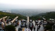 People arrive on the top of a restaurant on Margalla Hills in Islamabad on August 10, 2020, after government announced it would be lifting most of the country's remaining coronavirus restrictions after seeing new cases drop for several weeks. / AFP / Aami