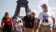FILE PHOTO: People wearing protective face masks walk at the Trocadero square near the Eiffel Tower in Paris as France reinforces mask-wearing as part of efforts to curb a resurgence of the coronavirus disease (COVID-19) across the country, August 9, 2020